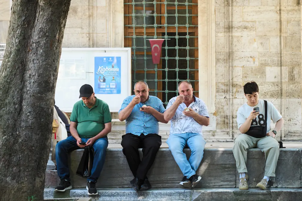2026-06-08_istanbul_men-resting-mosque-wall_dsc04439.jpg